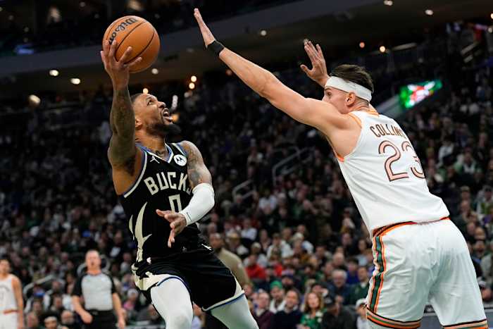 Dec 19, 2023; Milwaukee, Wisconsin, USA; Milwaukee Bucks guard Damian Lillard (0) shoots around San Antonio Spurs center Zach Collins (23) during the first quarter at Fiserv Forum.